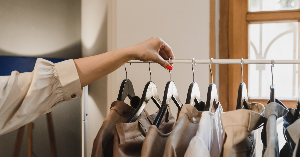 Hand sifting through a high-end clothing rack