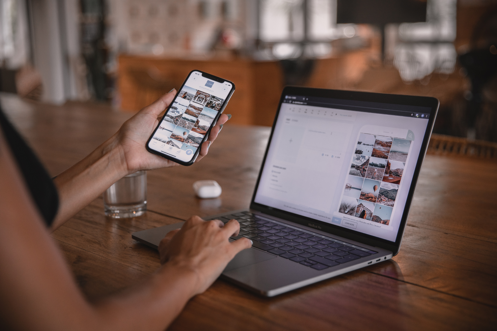 Person looking at images on her phone and computer simultaneously