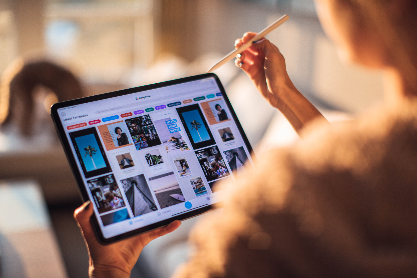 Woman looking at a tablet's screen that contains various images