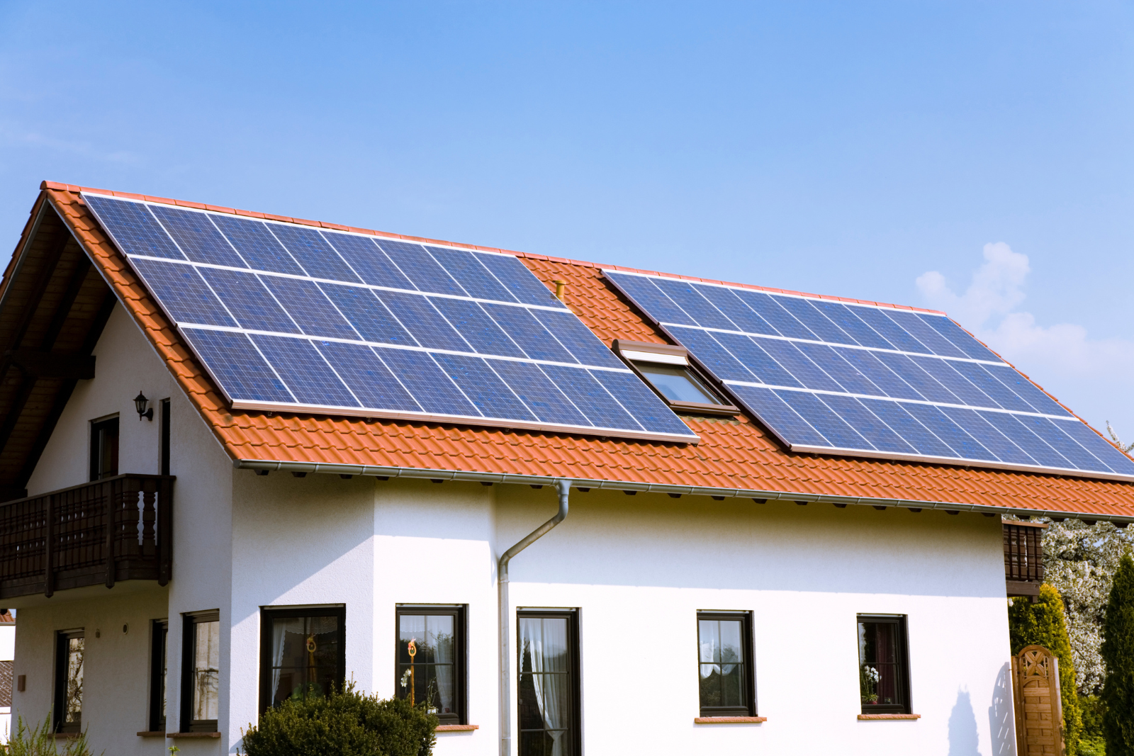 A white house with solar panels on the roof