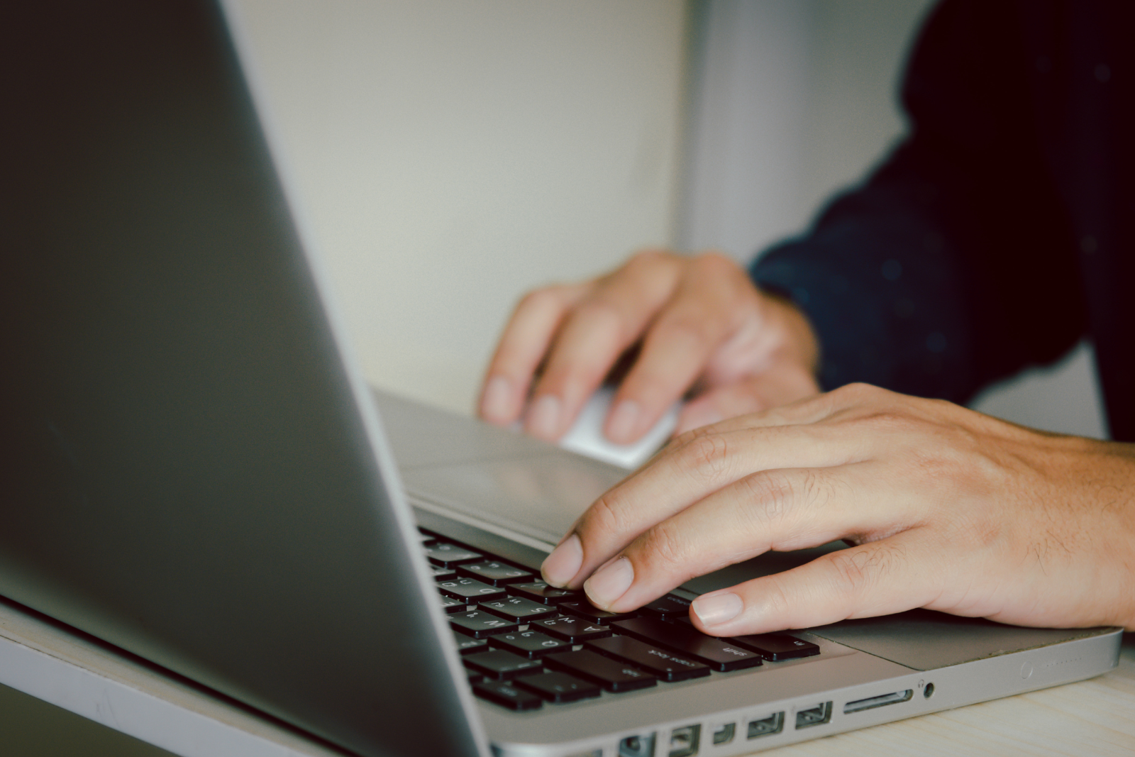 Person typing on a silver laptop