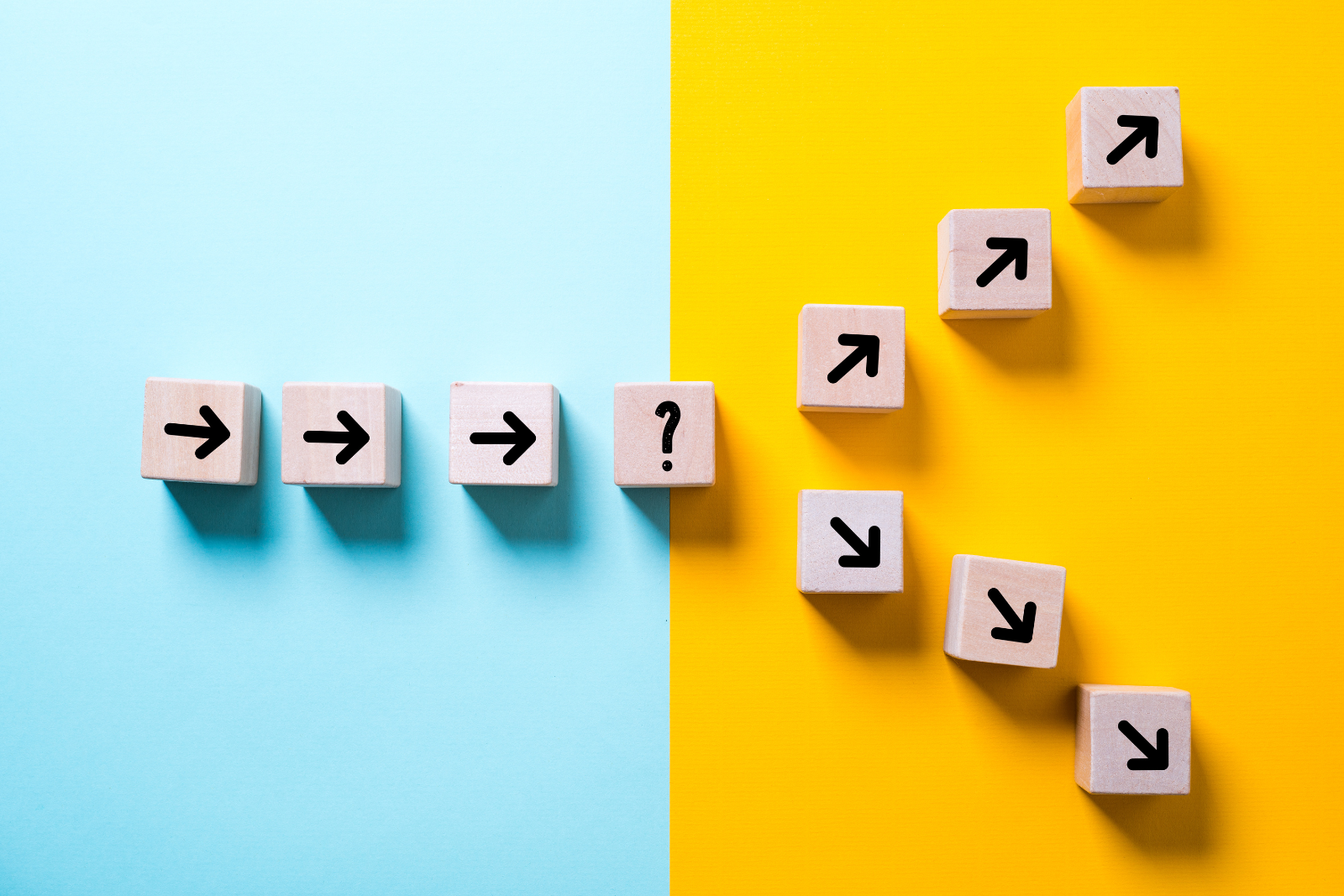 Blocks of wood with arrows pointing in different directions on a blue and yellow background