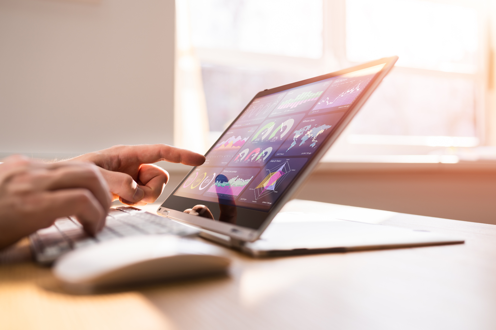 Person looking at a laptop screen that shows a reporting dashboard